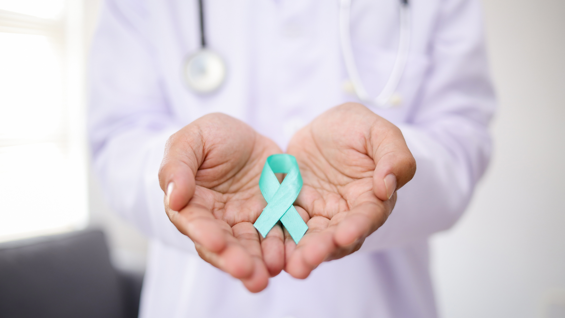 Doctor holding a teal awareness ribbon