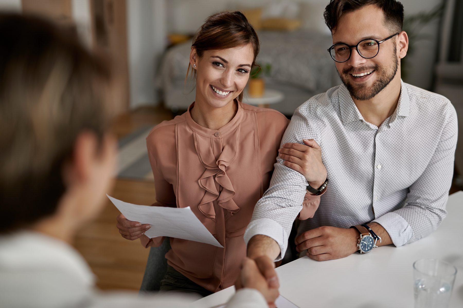 Couple shaking hands with their financial adviser
