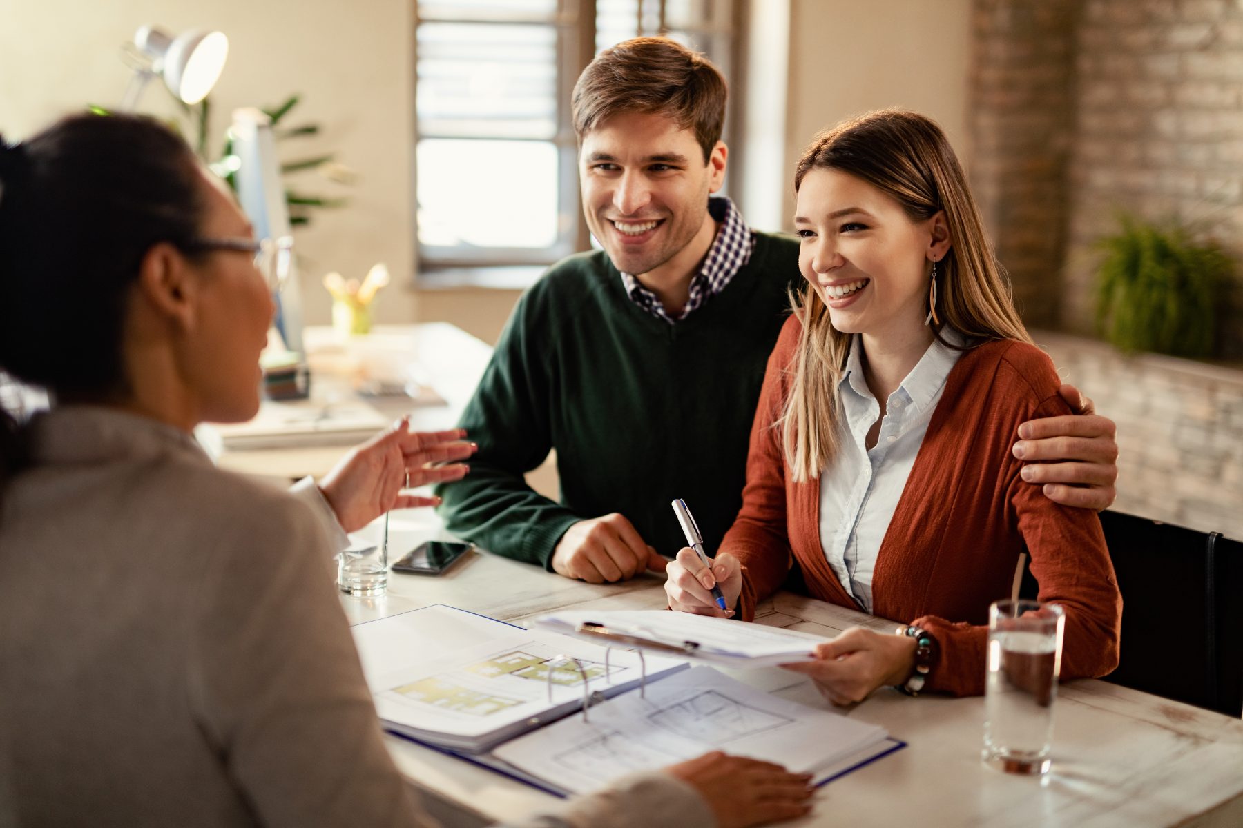 Couple signing paperwork with their adviser