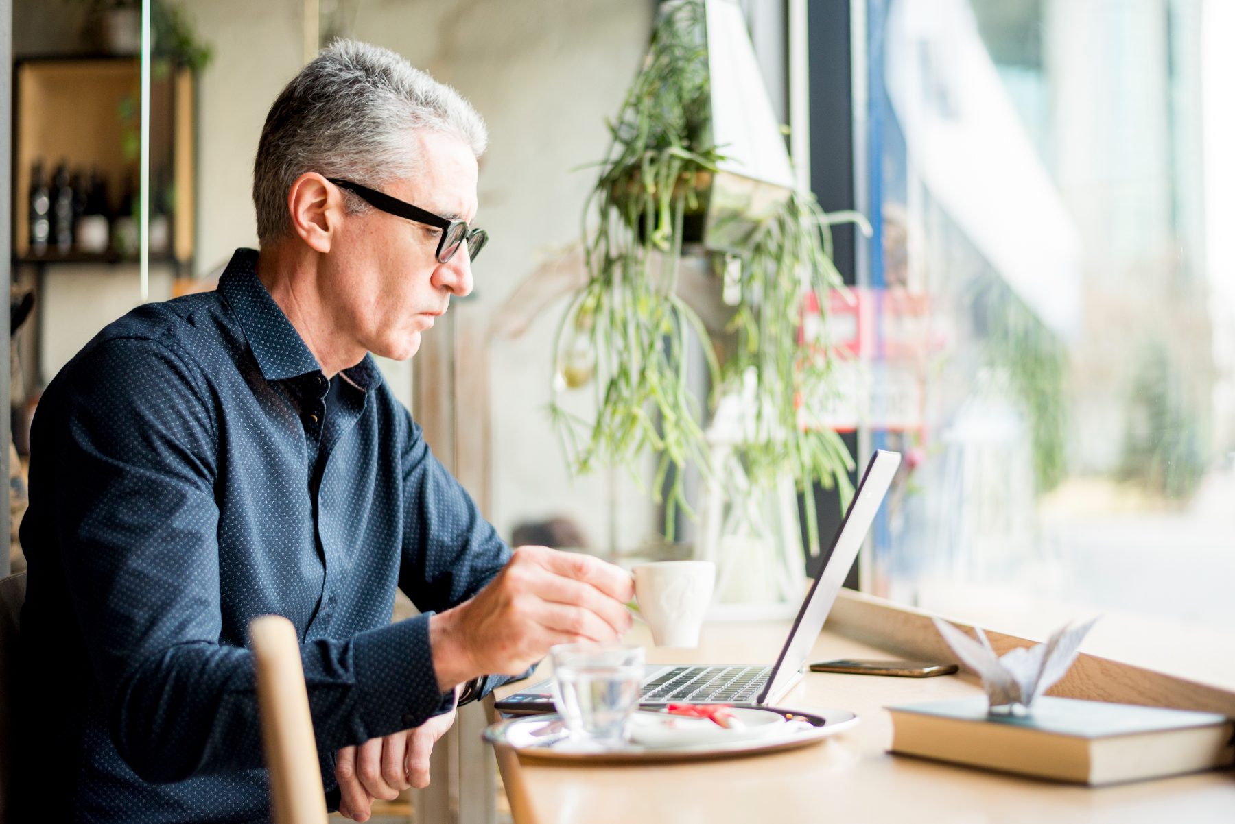 Self-employed man working on a laptop over coffee